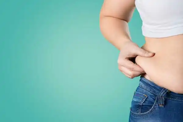 Image of woman pinching her love handles to show weight gain Renfrew